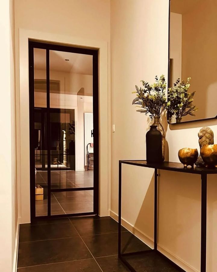 Stalen binnendeur met glas in een hal met sidetable