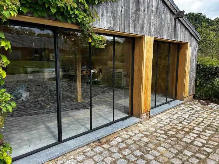 Stalen glaswand met schuifdeuren in een poolhouse