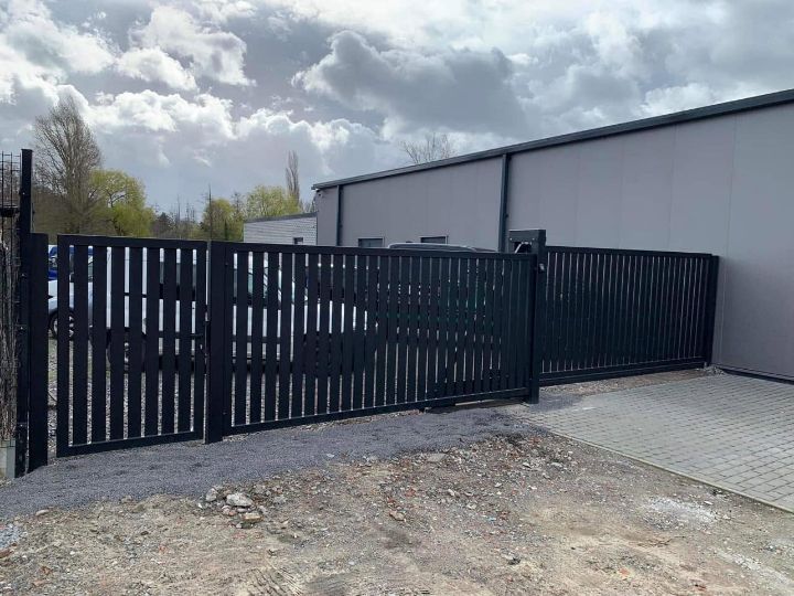 Stalen toegangspoort met spijlen aan een bedrijfsterrein